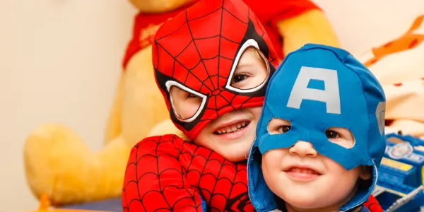 Two kids dressed in superhero costumes