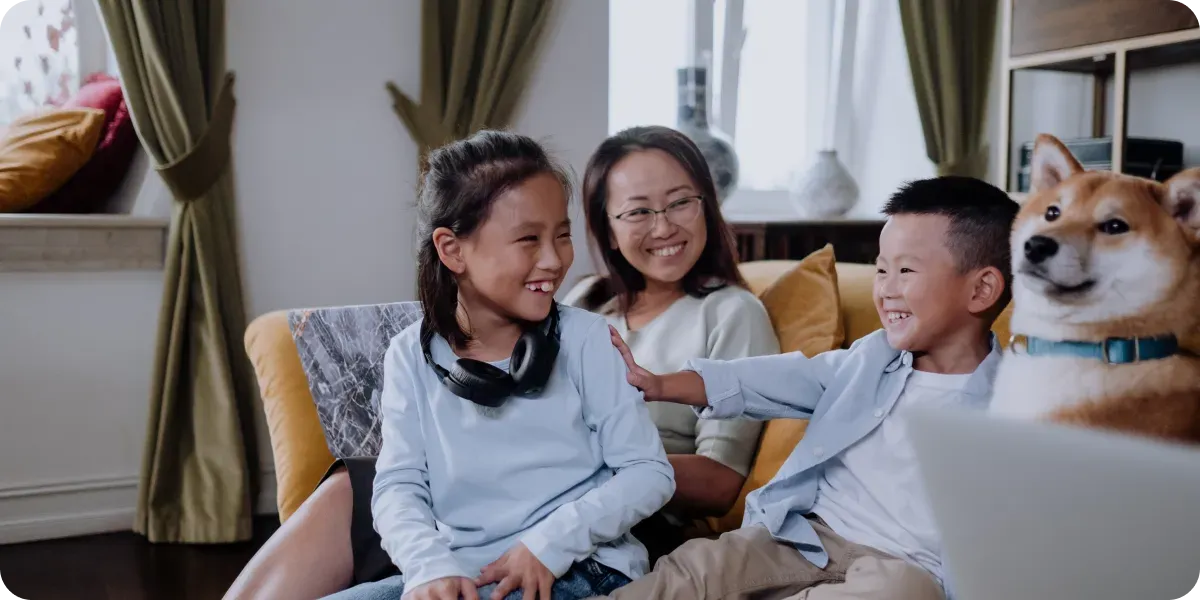 Three children and a dog sitting together on the couch
