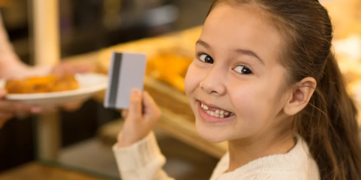 Girl paying with a Spriggy pocket money card