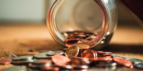 Coins spilling out of a glass jar