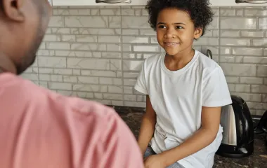 Dad and son chatting in the kitchen about money