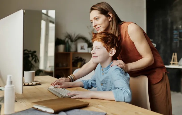 Mum and son using a computer together at a desk