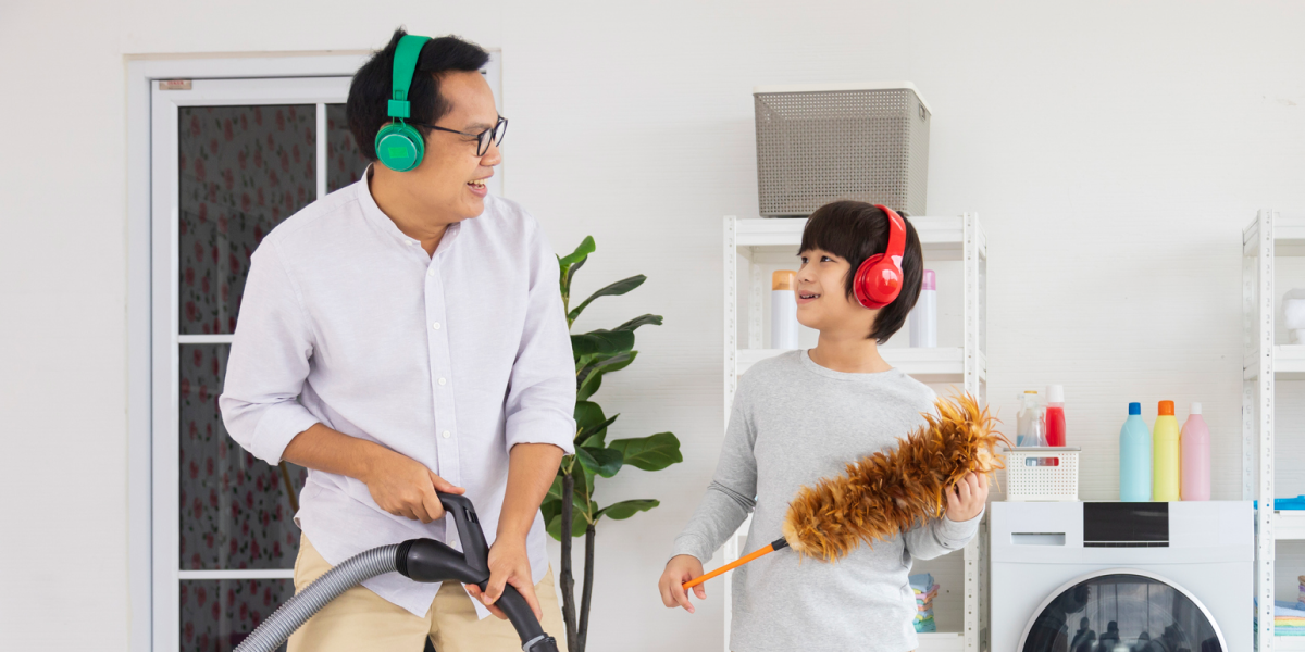 Dad and son vacuuming together in a laundry room