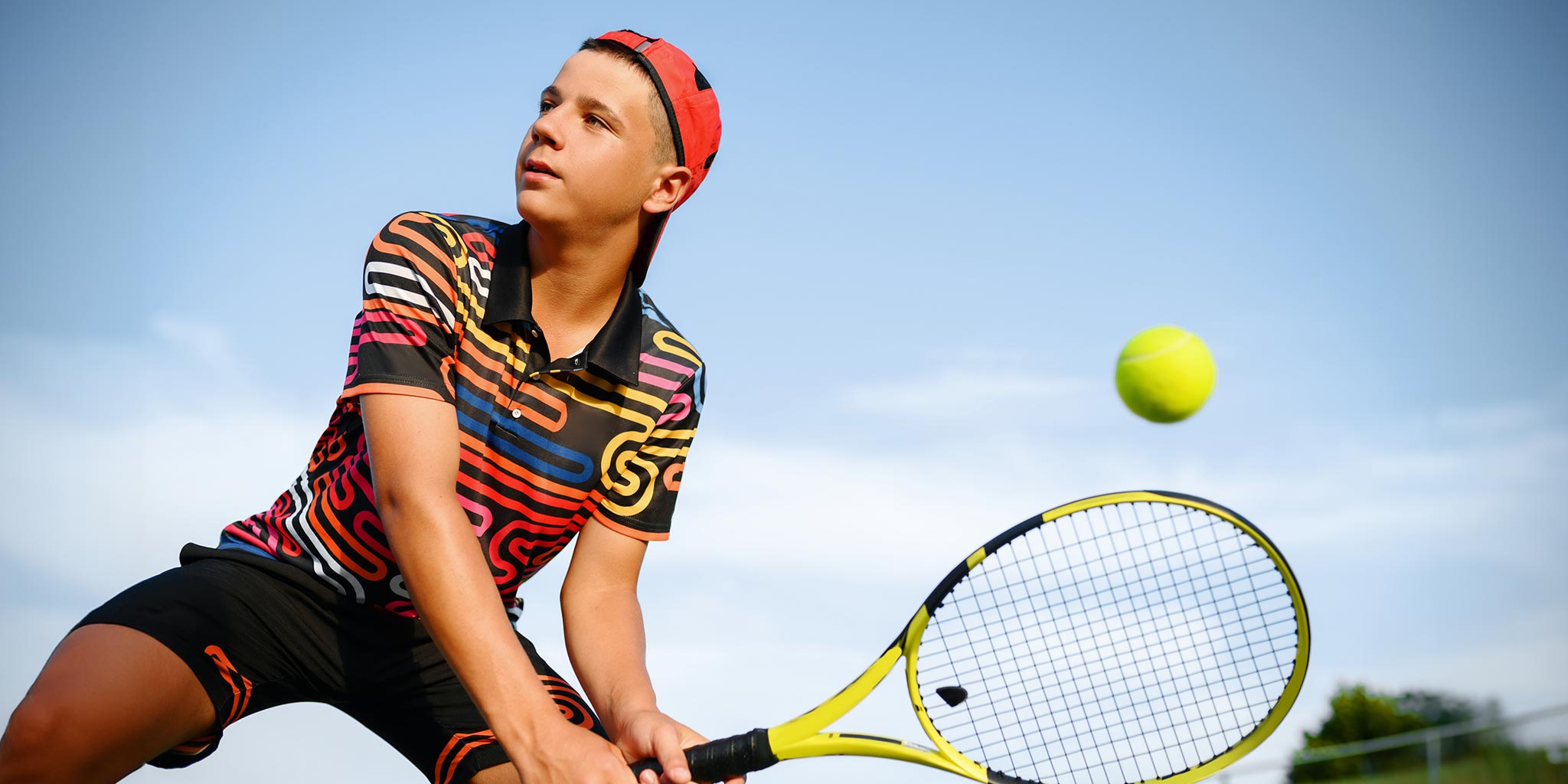 Young tennis player preparing to hit a ball on an outdoor court