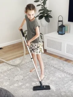 Girl vacuuming at home